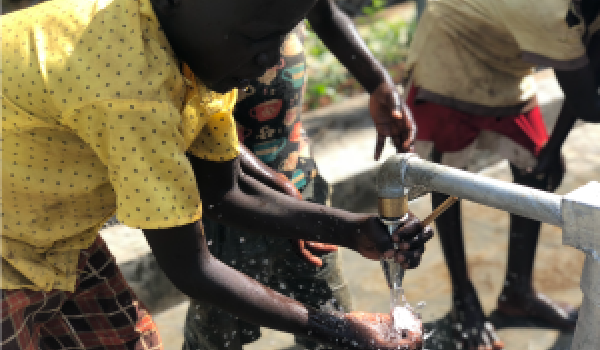 Thumbnail of a South Sudan child wetting a bar of soap under clean running water